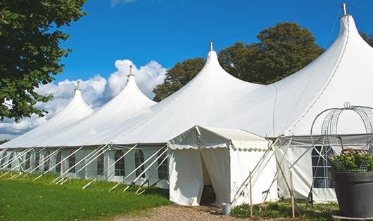 tall green portable restrooms assembled at a music festival, contributing to an organized and sanitary environment for guests in Milltown